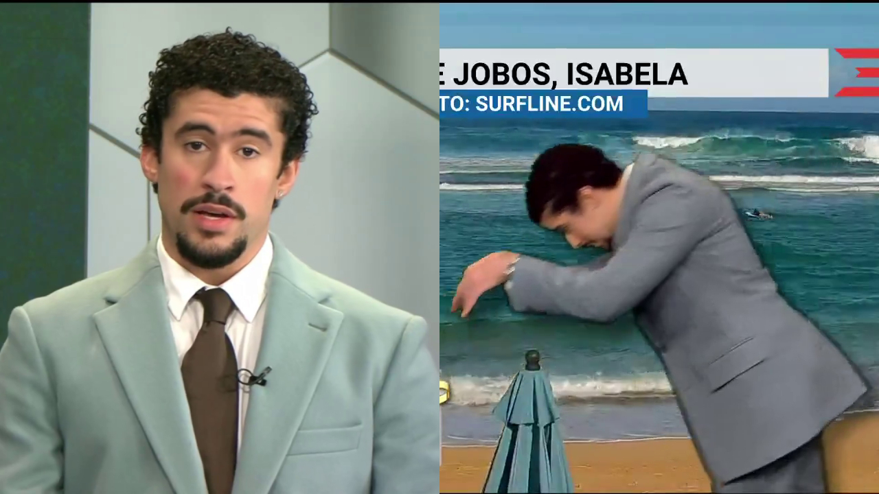 Bad Bunny in a light blue suit presents the weather in a studio and gestures dramatically in front of a beach backdrop.