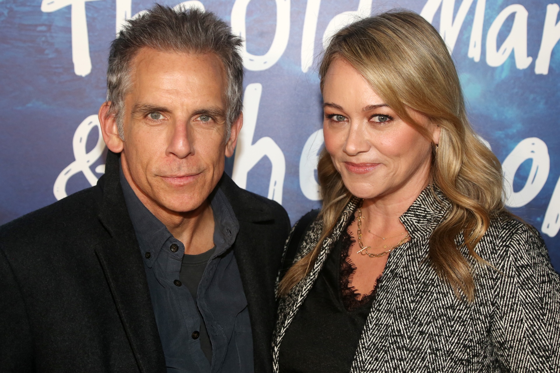 Ben Stiller and Christine Taylor at an event, posing together in front of a blue backdrop.