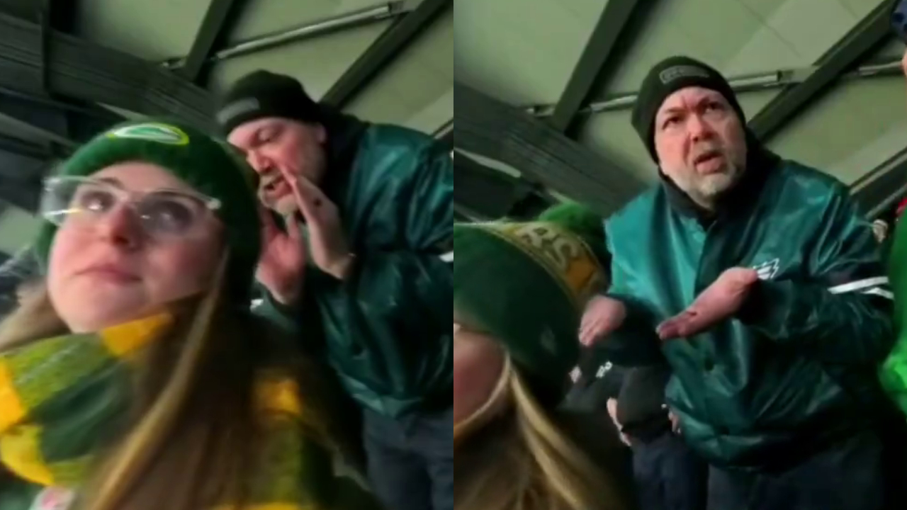 A man in Philadelphia Eagles gear shouting at a woman in a Green Bay Packers hat and scarf at a stadium.