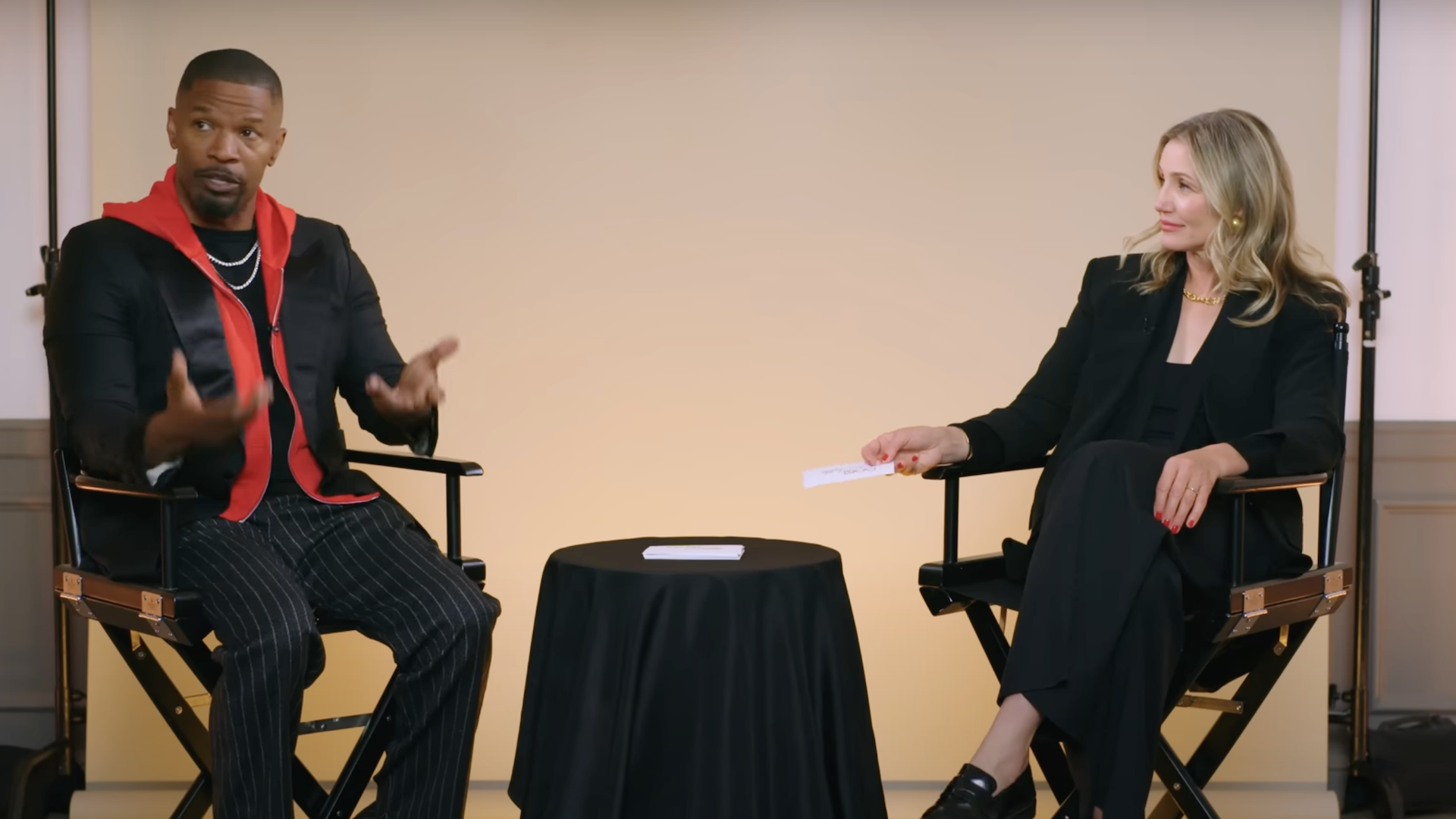 Jamie Foxx and Cameron Diaz sit on director's chairs, engaged in conversation. Jamie gestures expressively, while Cameron listens attentively.