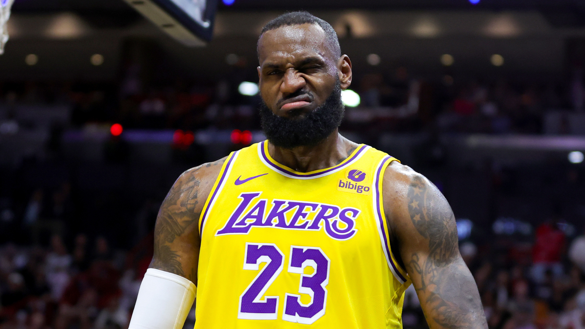 LeBron James in a Lakers jersey, making a determined expression during a basketball game.