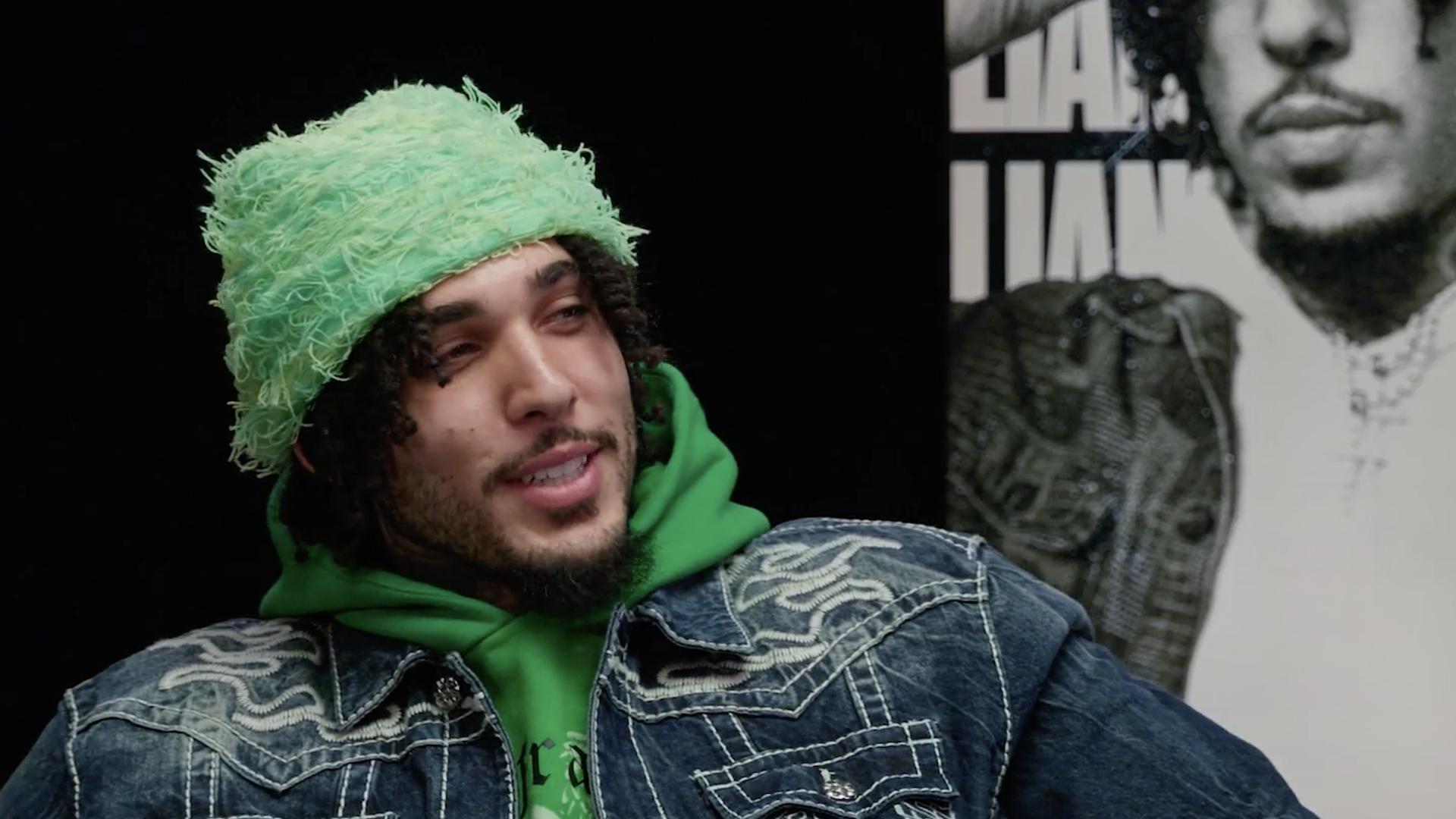 LiAngelo Ball wearing a fuzzy green hat and embroidered denim jacket.
