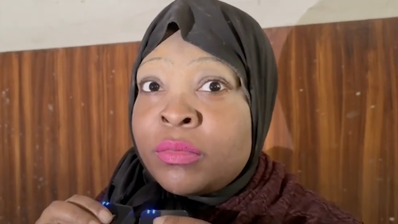 Onijah Andrew Robinson wearing a black headscarf and pink lipstick, looking directly at the camera.