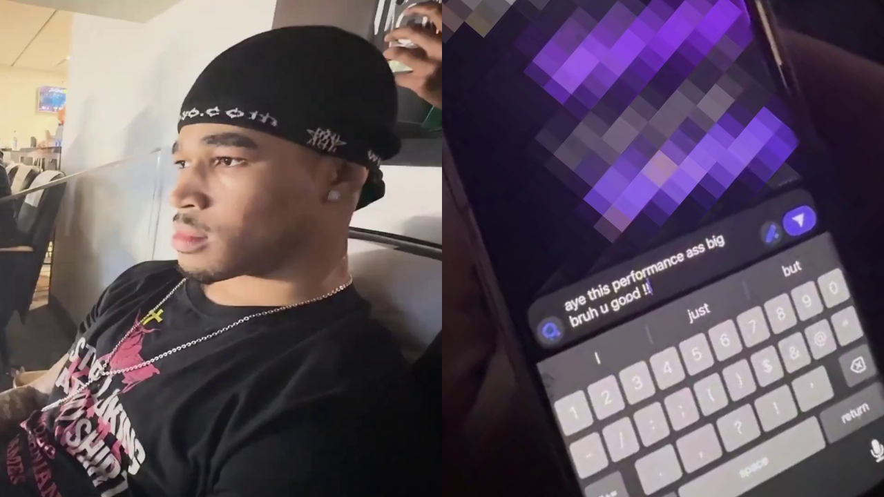 Plaqueboymax holding a smartphone with a blurred screen, sitting in a stadium.