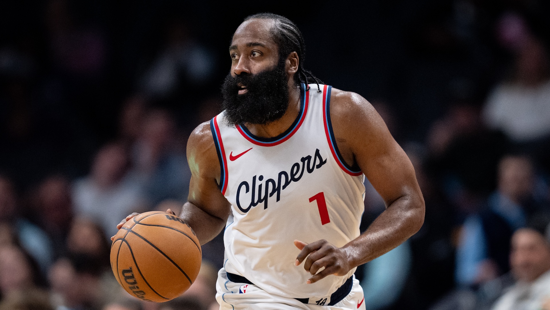 James Harden, wearing a Clippers jersey, dribbles a basketball during a game.