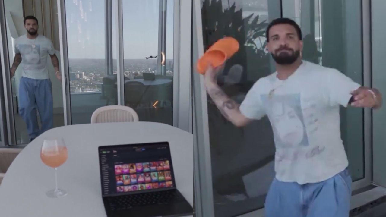 Drake in casual clothes throws an orange slipper indoors. A laptop and drink are on a table outside.
