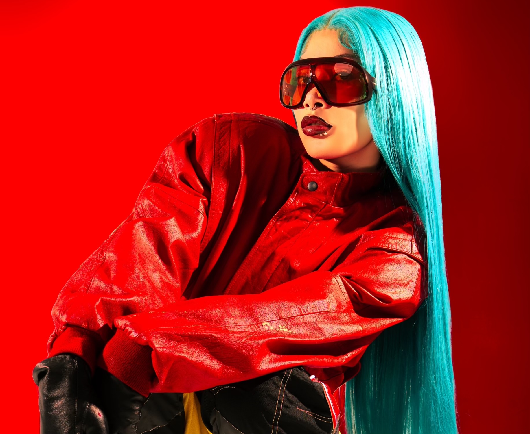 Underground rapper Molly Santana wearing blue hair and a red suit