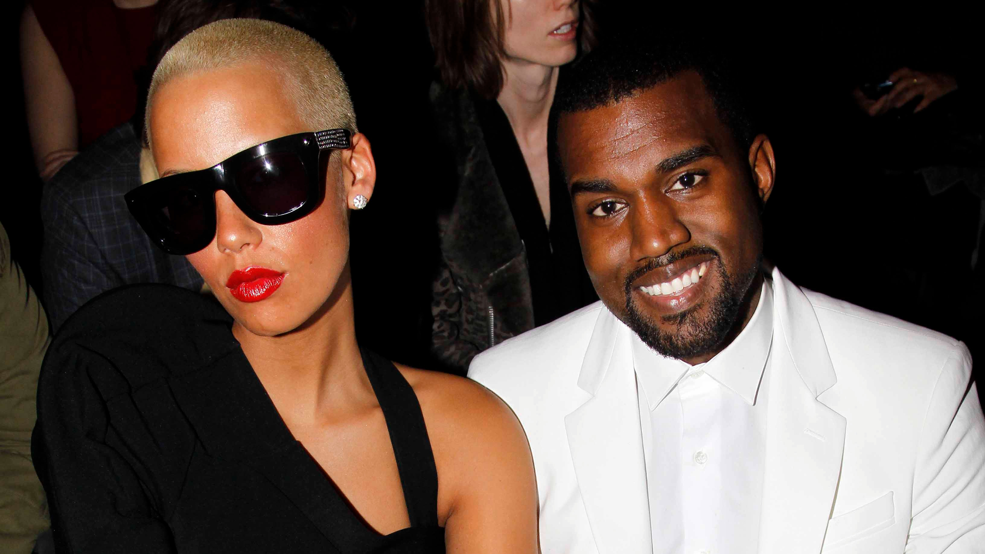 Amber Rose sits next to Kanye West.