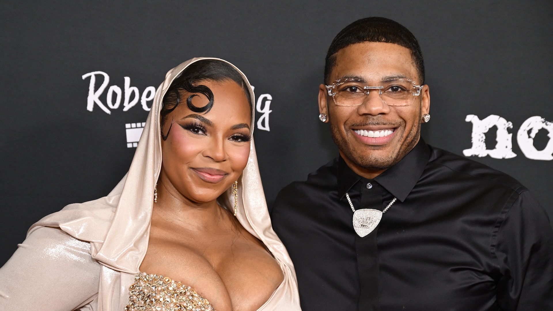 LOS ANGELES, CALIFORNIA - FEBRUARY 18: (L-R) Actor/singer Ashanti and singer Nelly attend the Los Angeles premiere of Robert Craig Films' "No Address" at DGA Theater Complex on February 18, 2025 in Los Angeles, California.