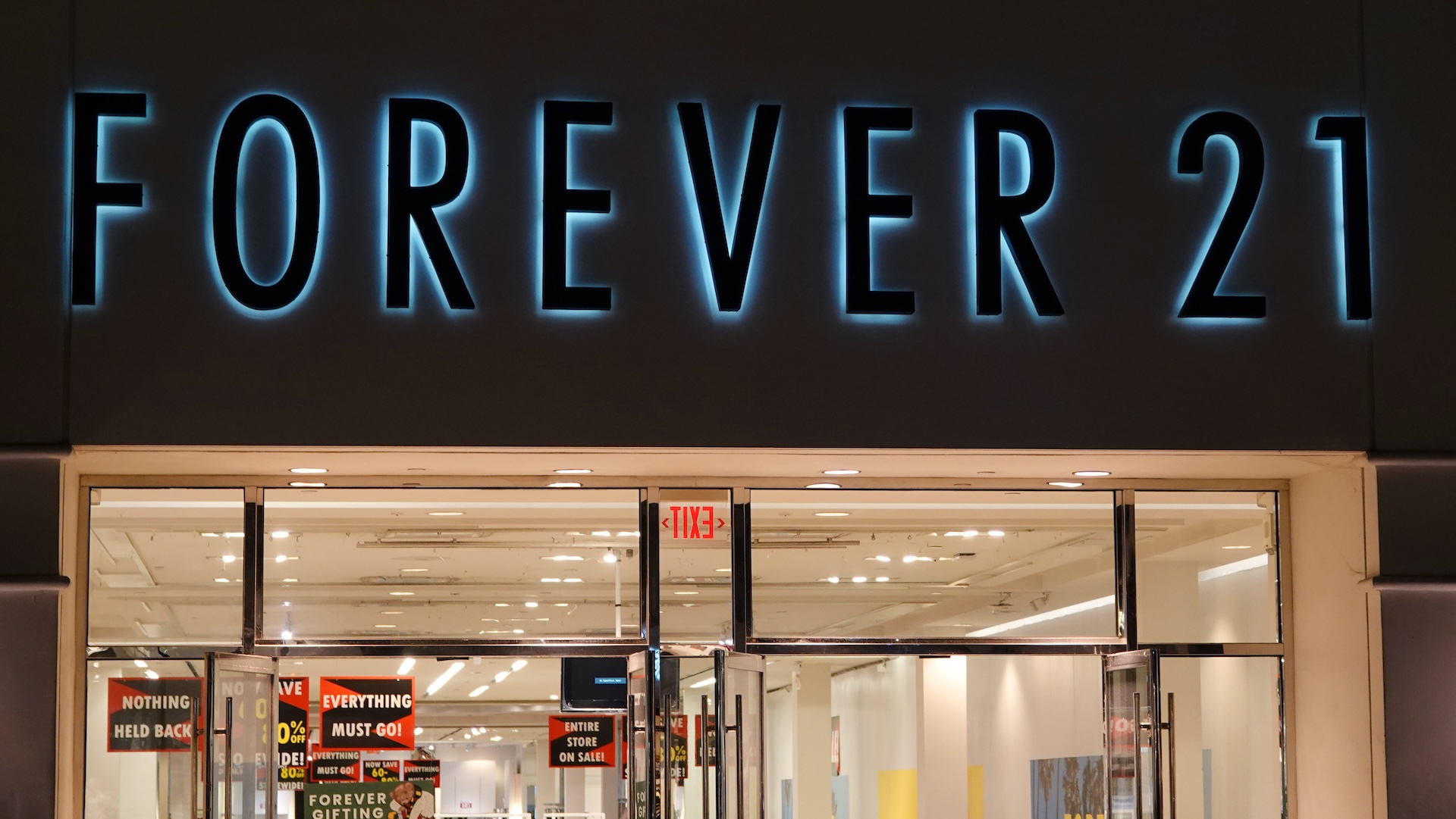 Storefront of Forever 21 with sale signs visible inside. The store is well-lit and appears to be having a clearance event.