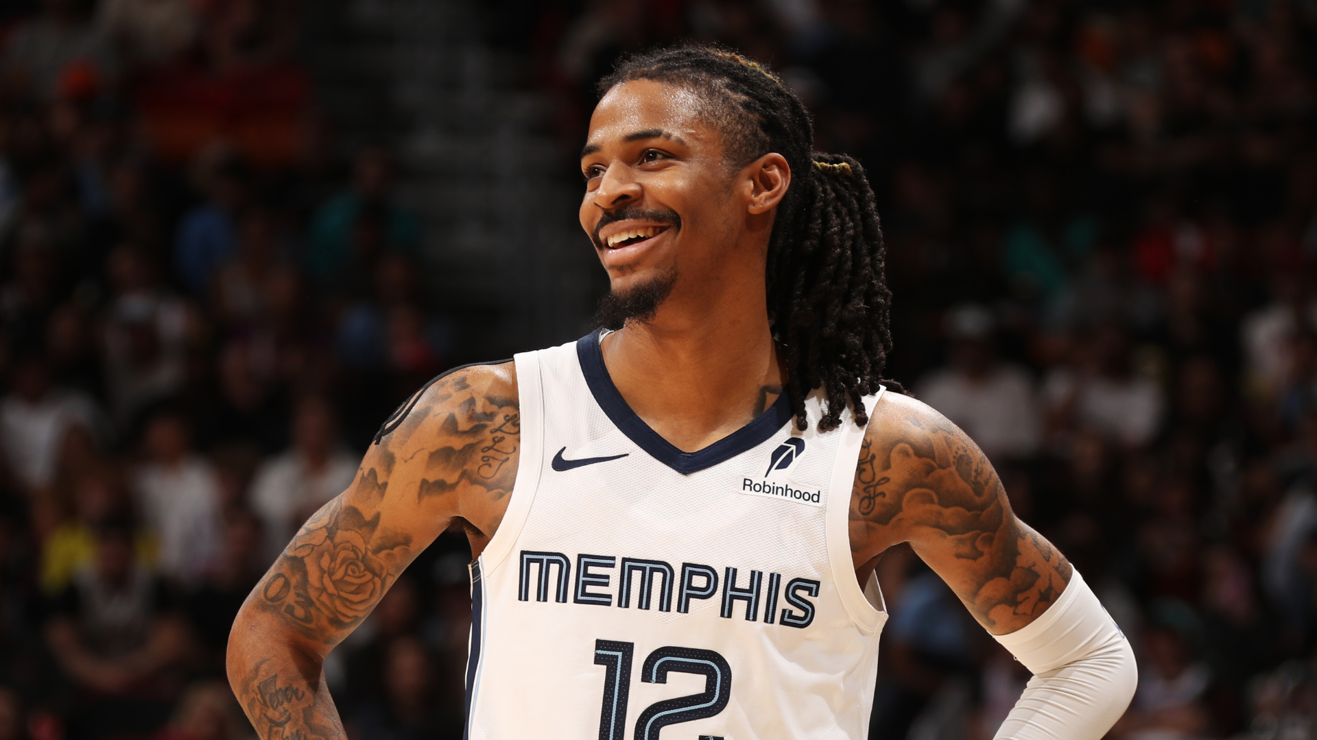 Ja Morant in a Memphis jersey, number 12, smiling on the court.