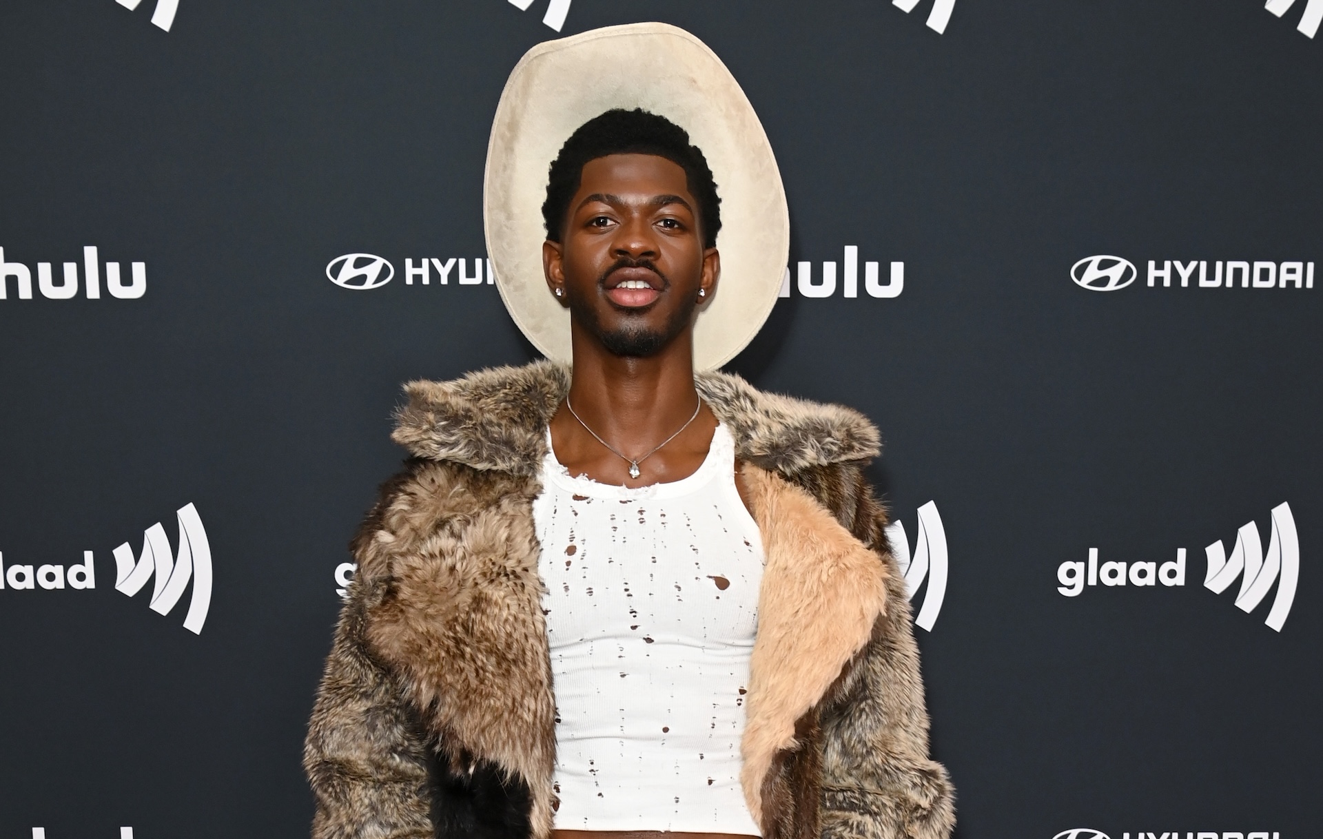 Lil Nas X Instagram story with GUYS I AM OK!! STOP BEING SAD FOR ME! SHAKE UR ASS FOR ME INSTEAD! with Huey song playing.