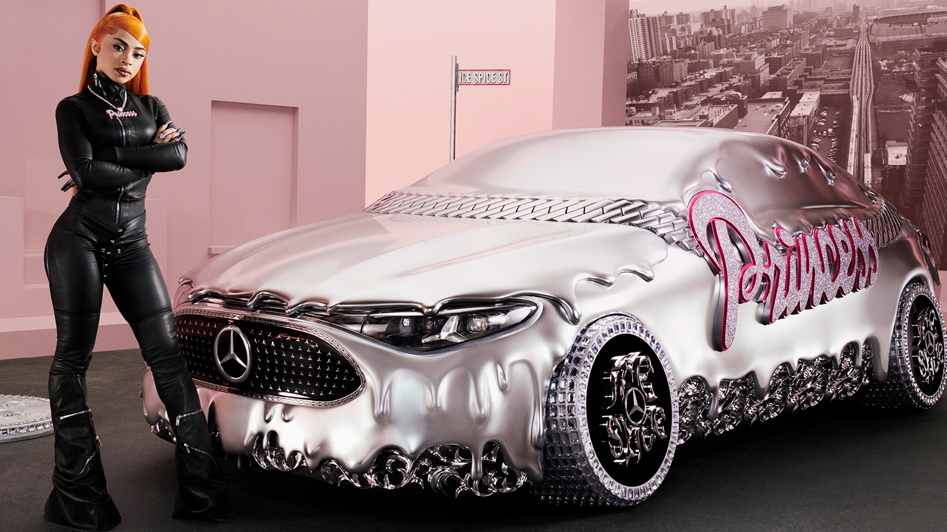 A woman in a black outfit stands beside a futuristic silver Mercedes-Benz with "Princess" in pink. The scene is set in a modern, pink room.