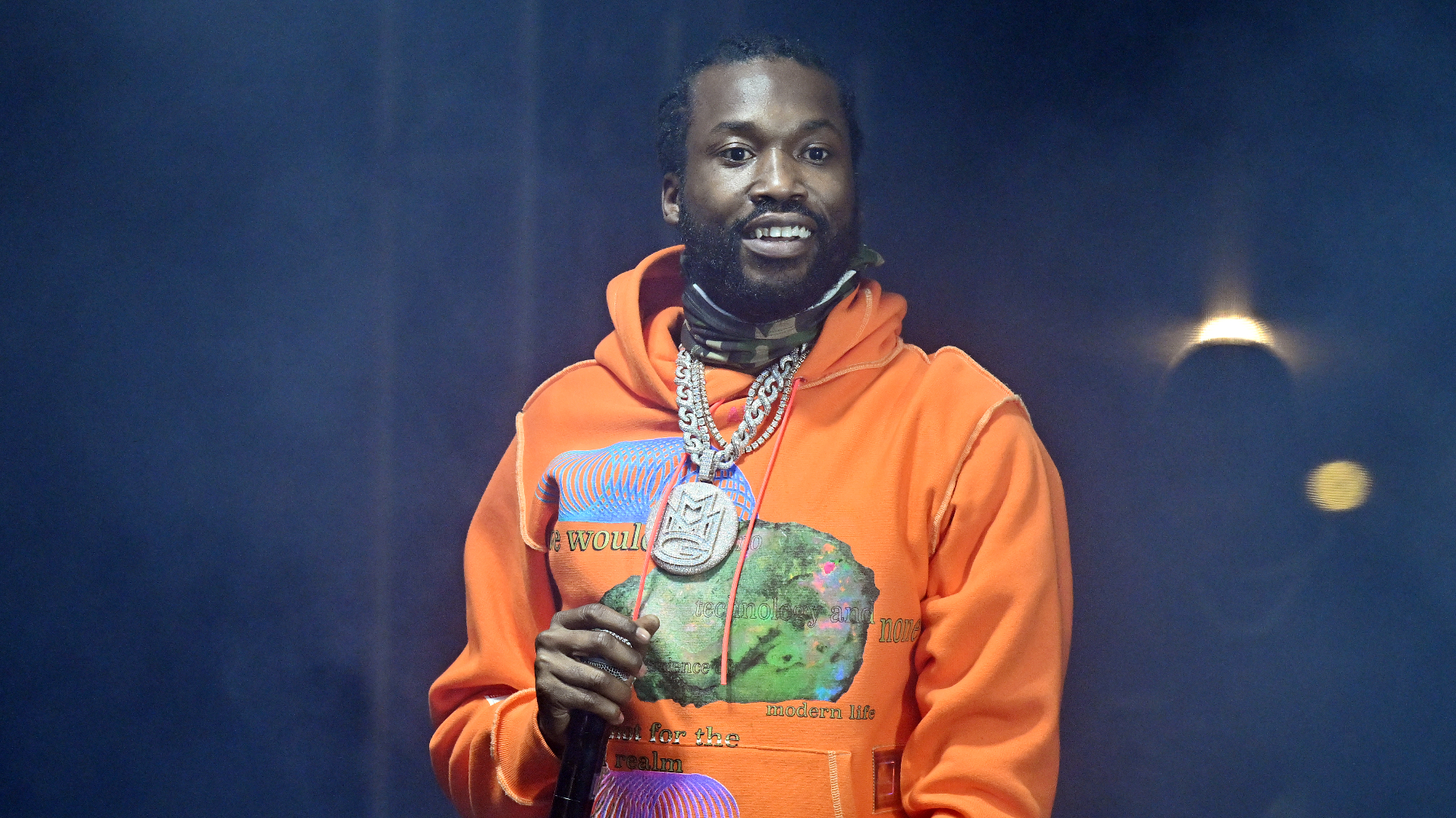 Rapper Meek Mill on stage, holding a microphone.