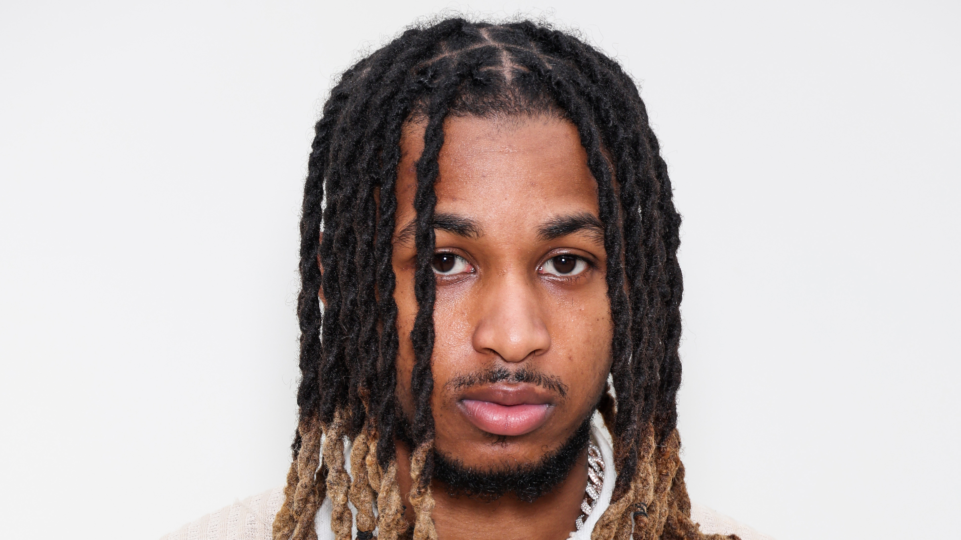 DDG with a neutral expression, against a plain background.