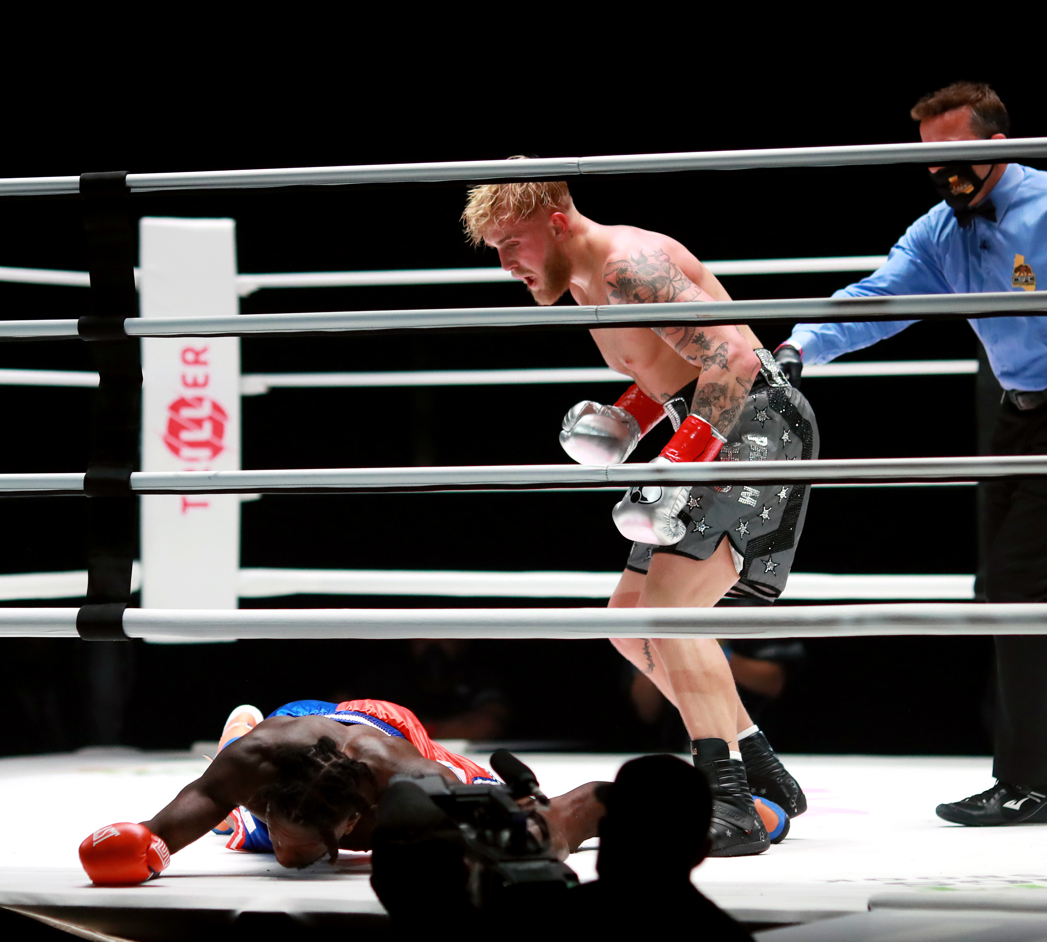 Jake Paul stands over Nate Robinson after knocking him out in their November 2020 boxing match.