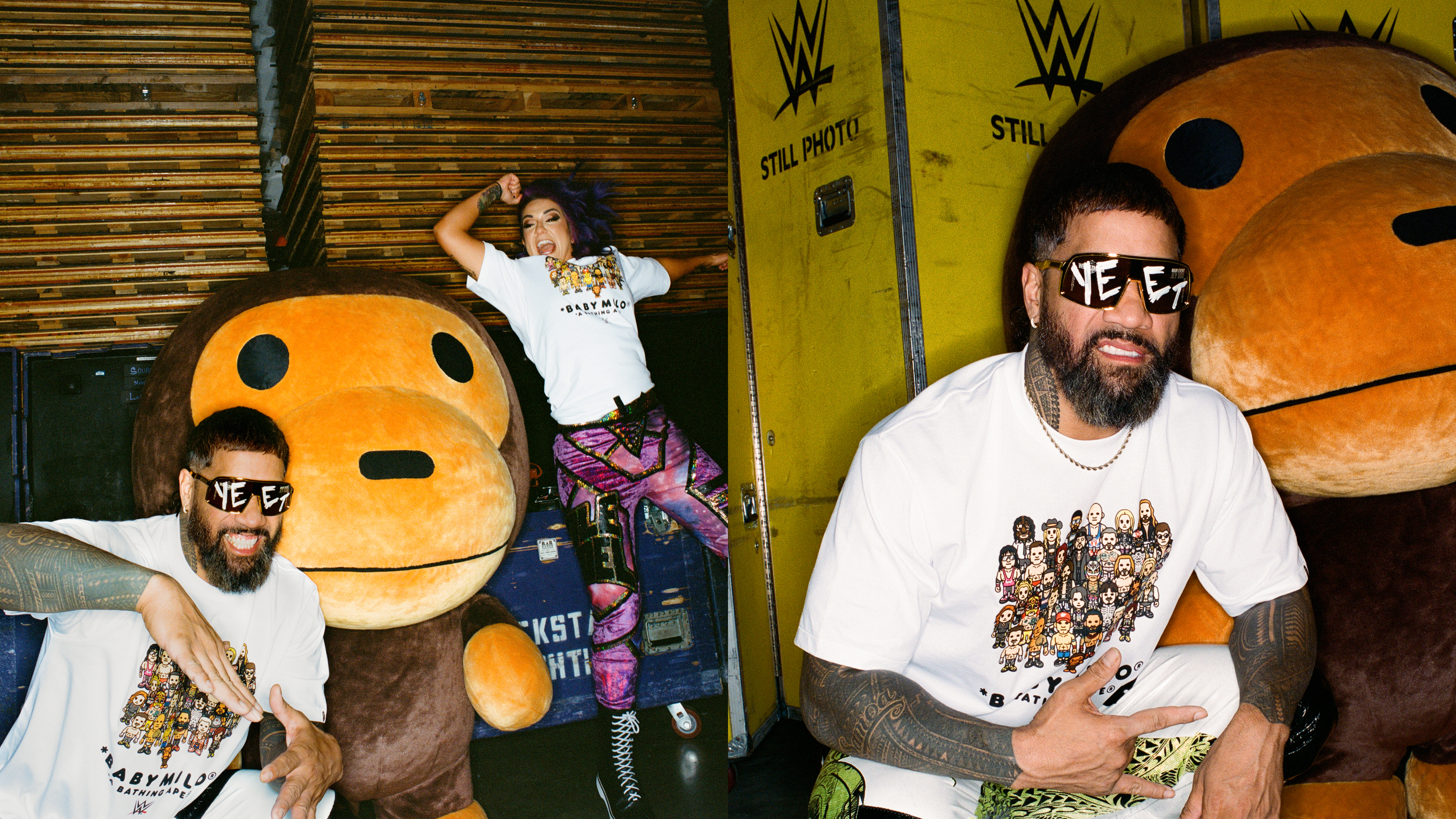 Two people posing with a large plush character. One wears sunglasses and a graphic tee, the other has colorful pants and a white shirt.