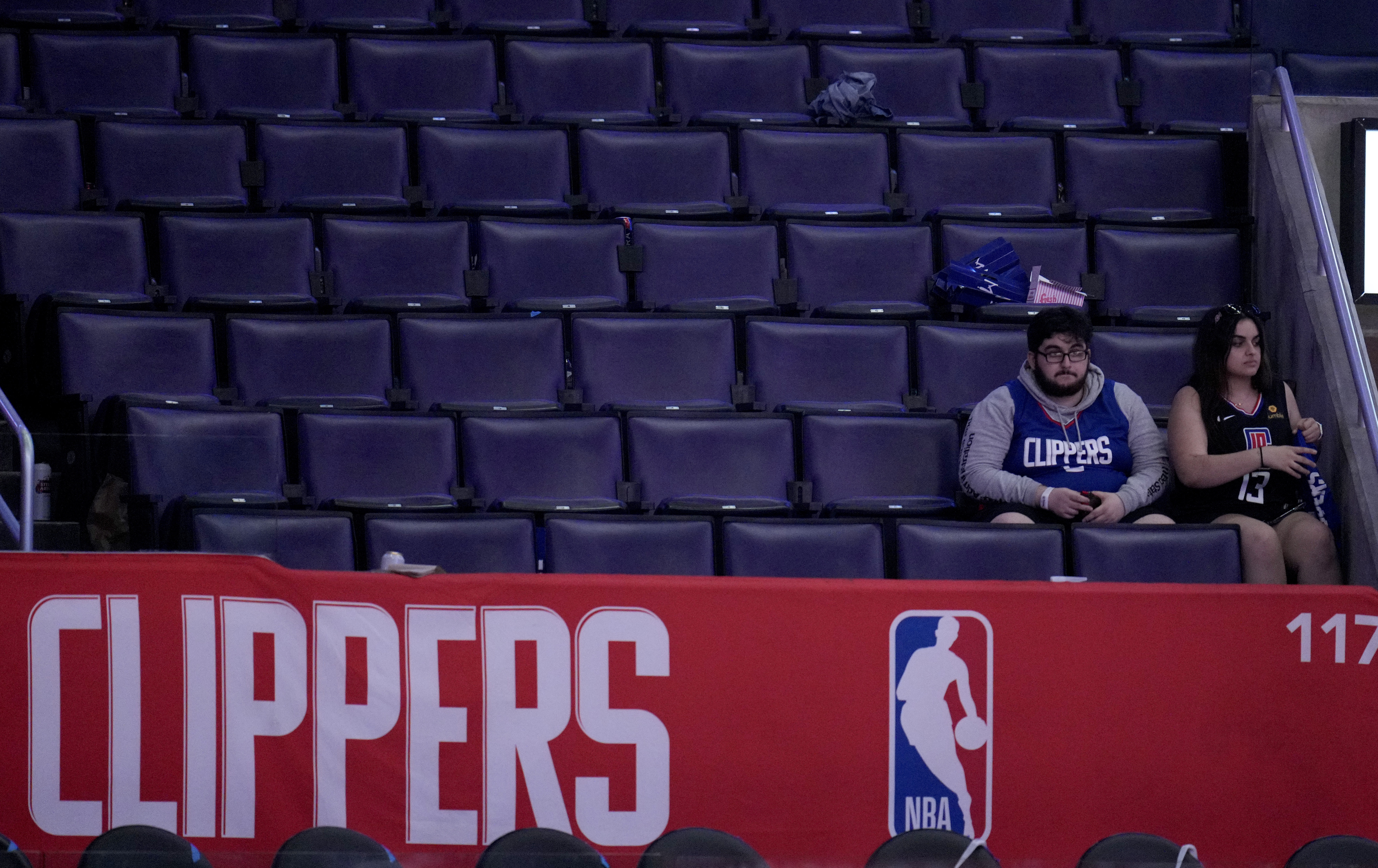 Two Clippers fans sit alone during a playoff series in 2021.
