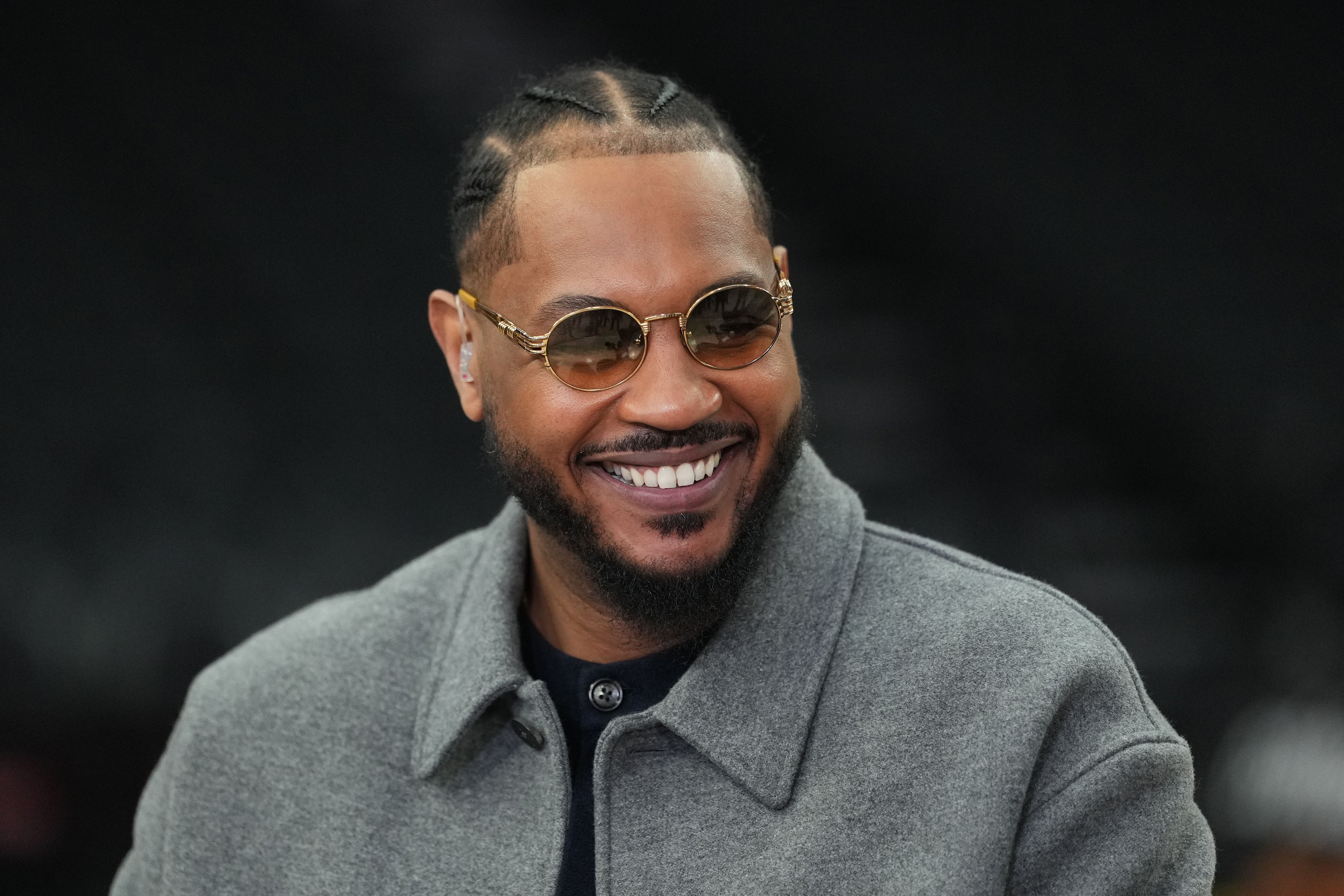 Carmelo Anthony sits courtside during the pregame for a Portland Trail Blazers-Phoenix Suns game in Portland.