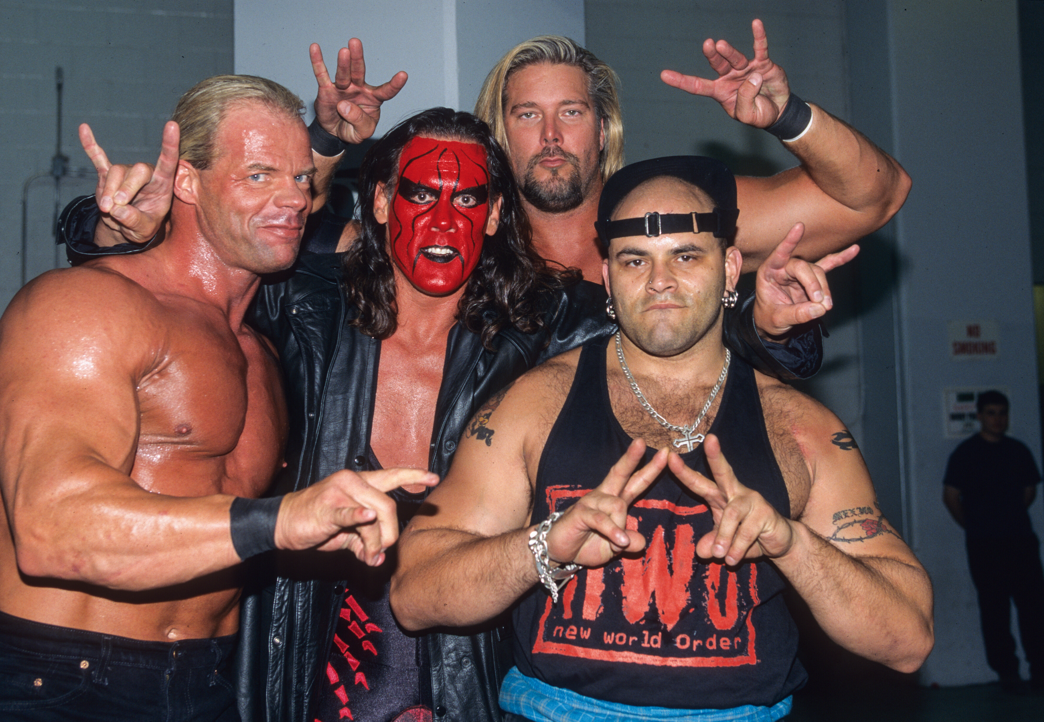 nWo Wolfpac members Lex Luger, Sting, Kevin Nash, and Konnan throw up the too sweet hand gesture.