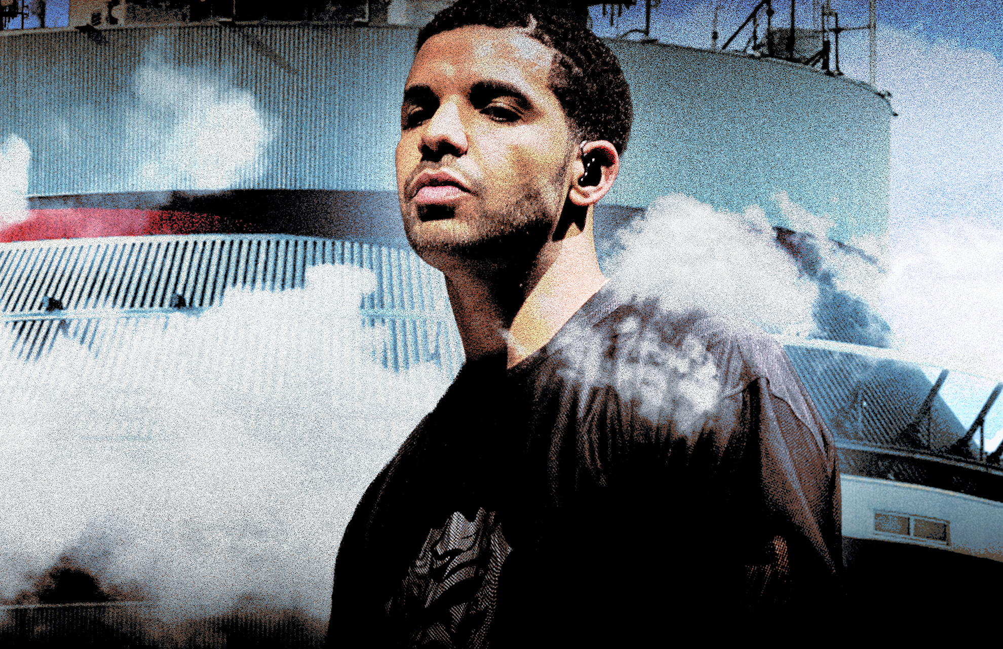 Drake stands confidently against a backdrop of clouds and a large industrial structure. He is standing in front of the cover for VIEWS.