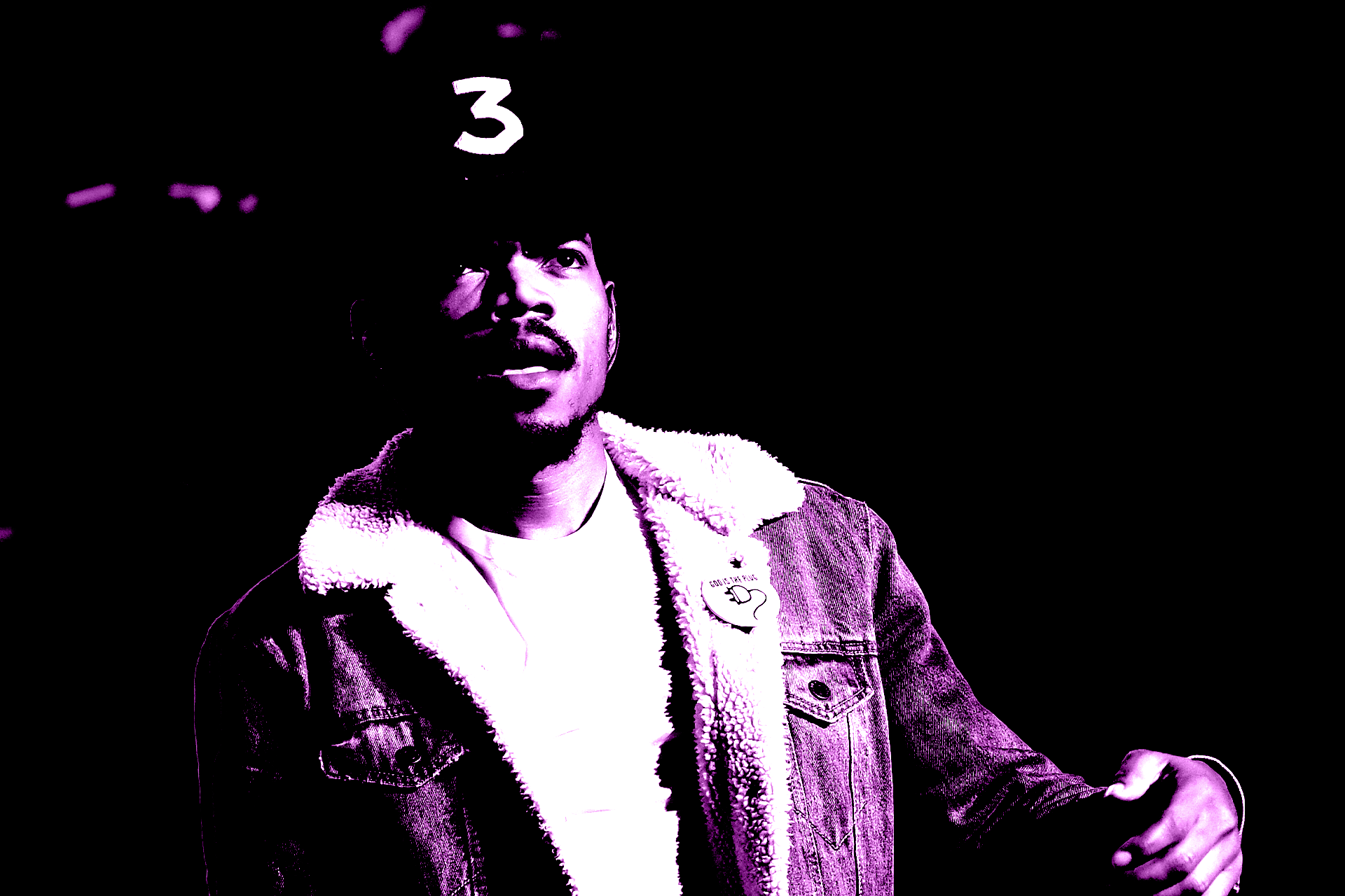 Chance the Rapper wearing a denim jacket and a cap with the number "3" on it, in a purple-tinted image. This was during the Coloring Book era.