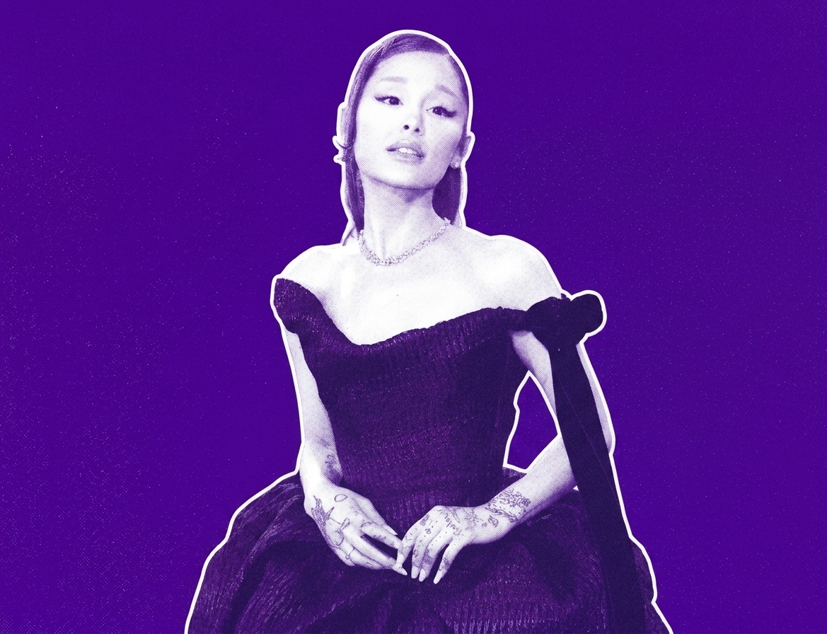 Ariana Grande in a stylized purple-toned image, wearing an elegant off-shoulder dress and displaying tattoos on her hands.