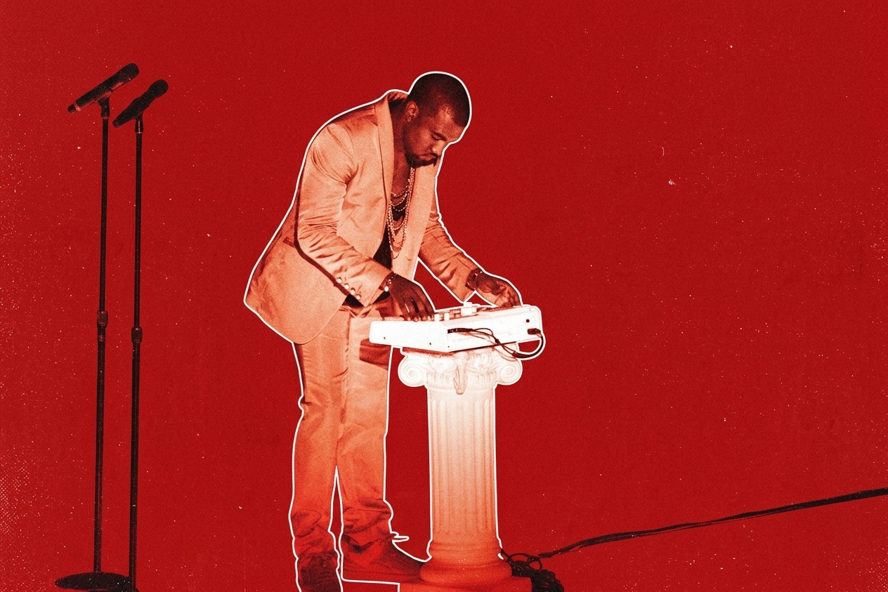 Kanye West in a suit using a keyboard on a pedestal against a red background, with two microphones nearby.