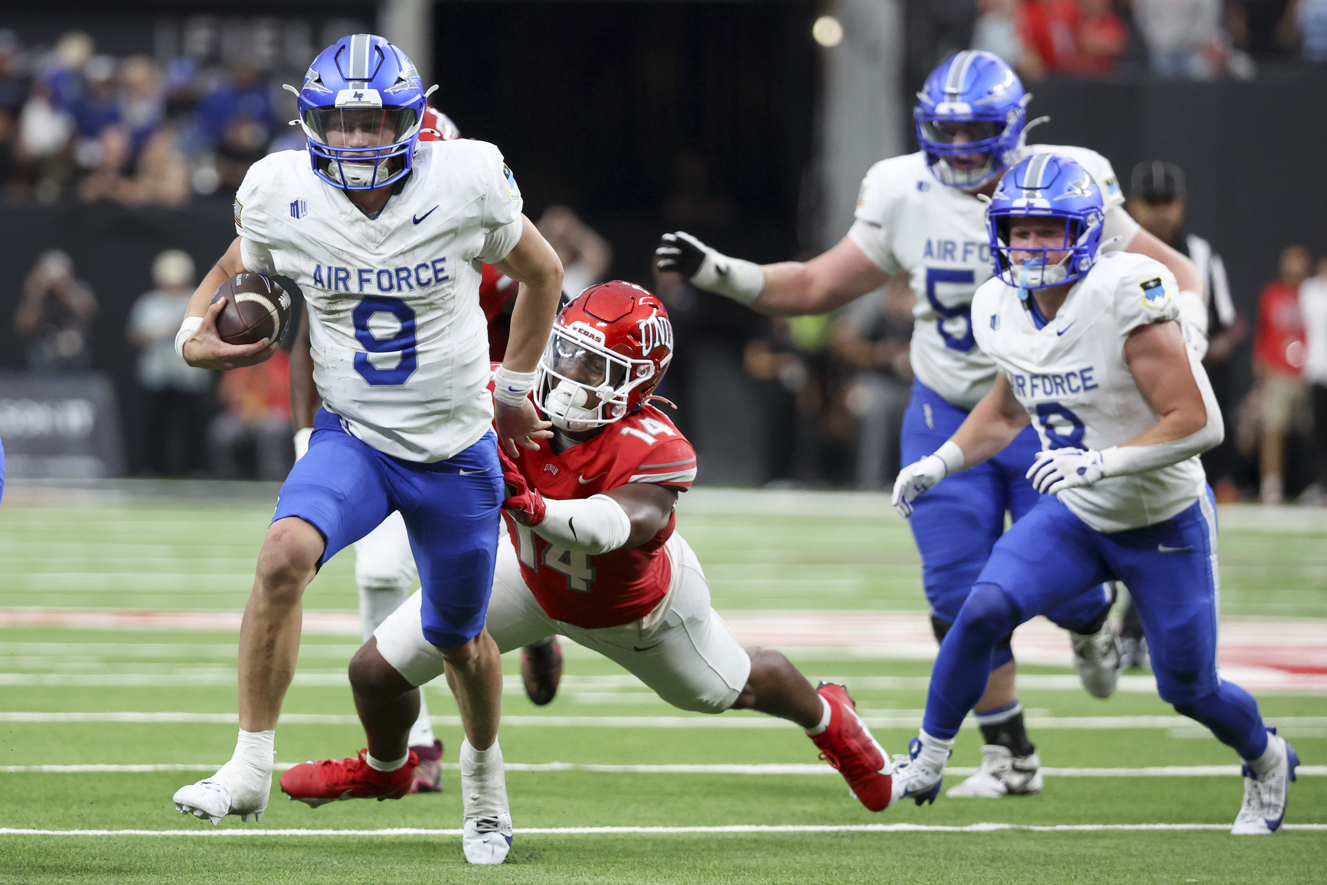 Liam Szarka runs over a defender during an Air Force football game.