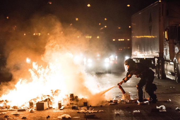 A policeman tries to put out a fire on the I-85.
