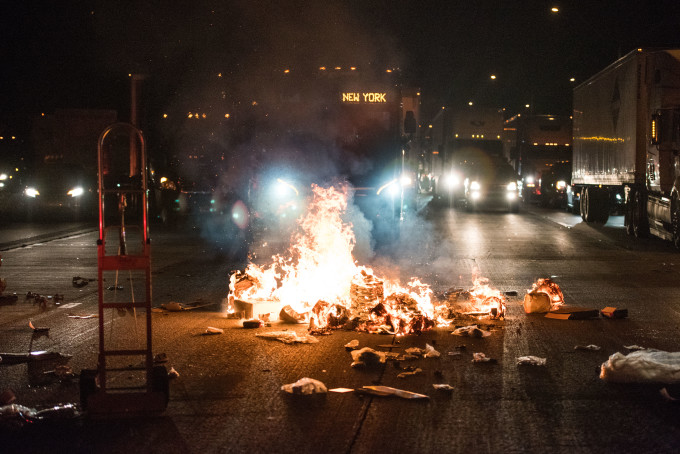 A fire set by protesters burns near a bus on the I-85 (Interstate 85) during protests
