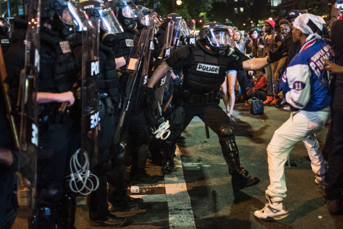A police officer attempts to grab a demonstrator.