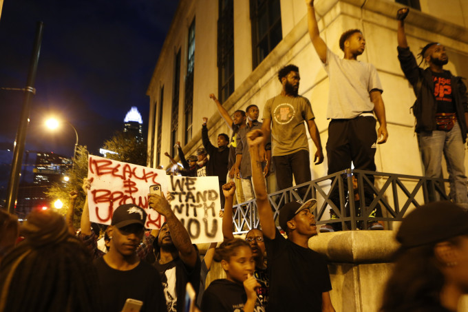 Protesters raise fists outside Charlotte Police department.
