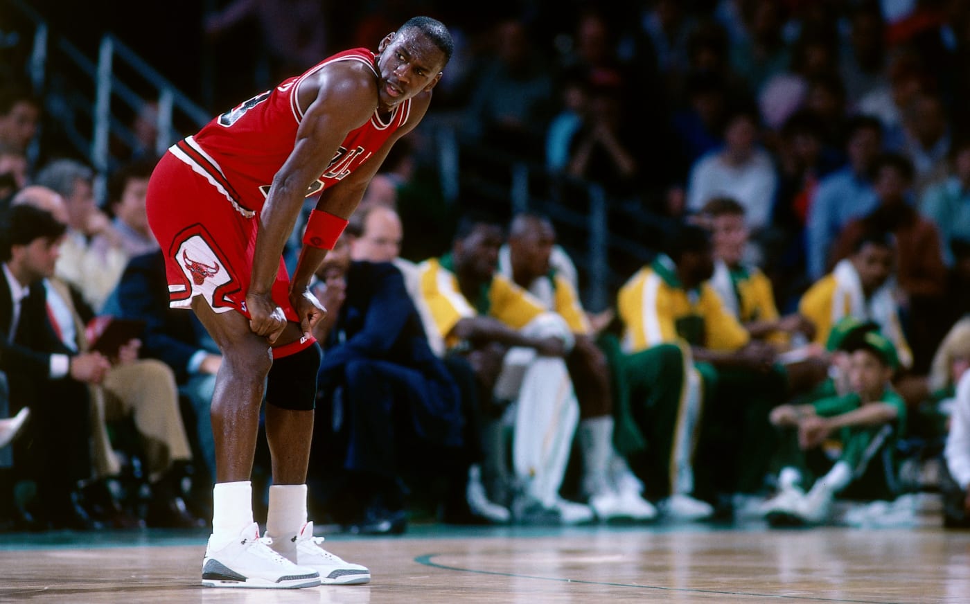 Michael Jordan with his hands on his knees in a Chicago Bulls uniform in 1988