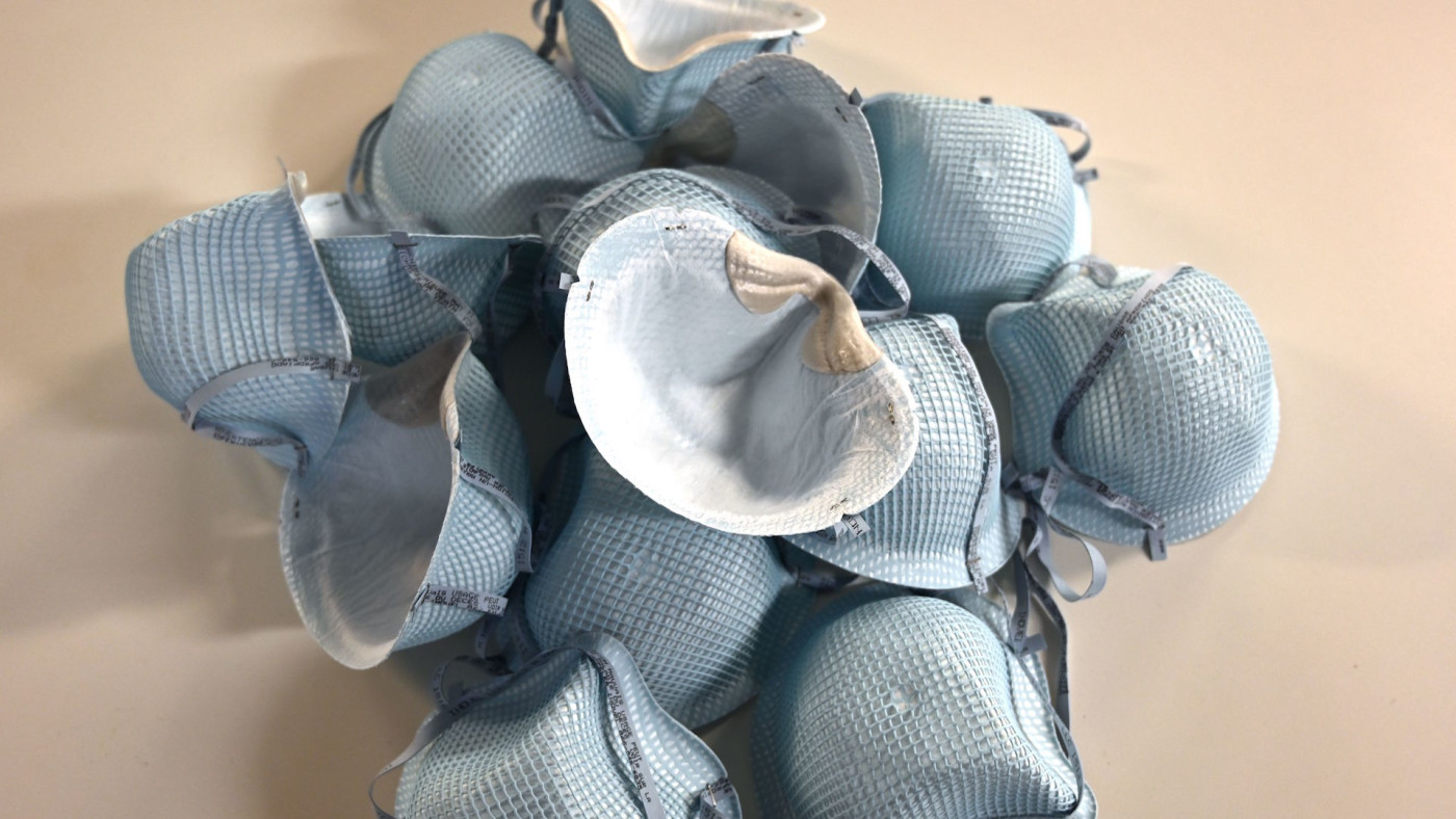 Protective N-95 face masks lie on a table.