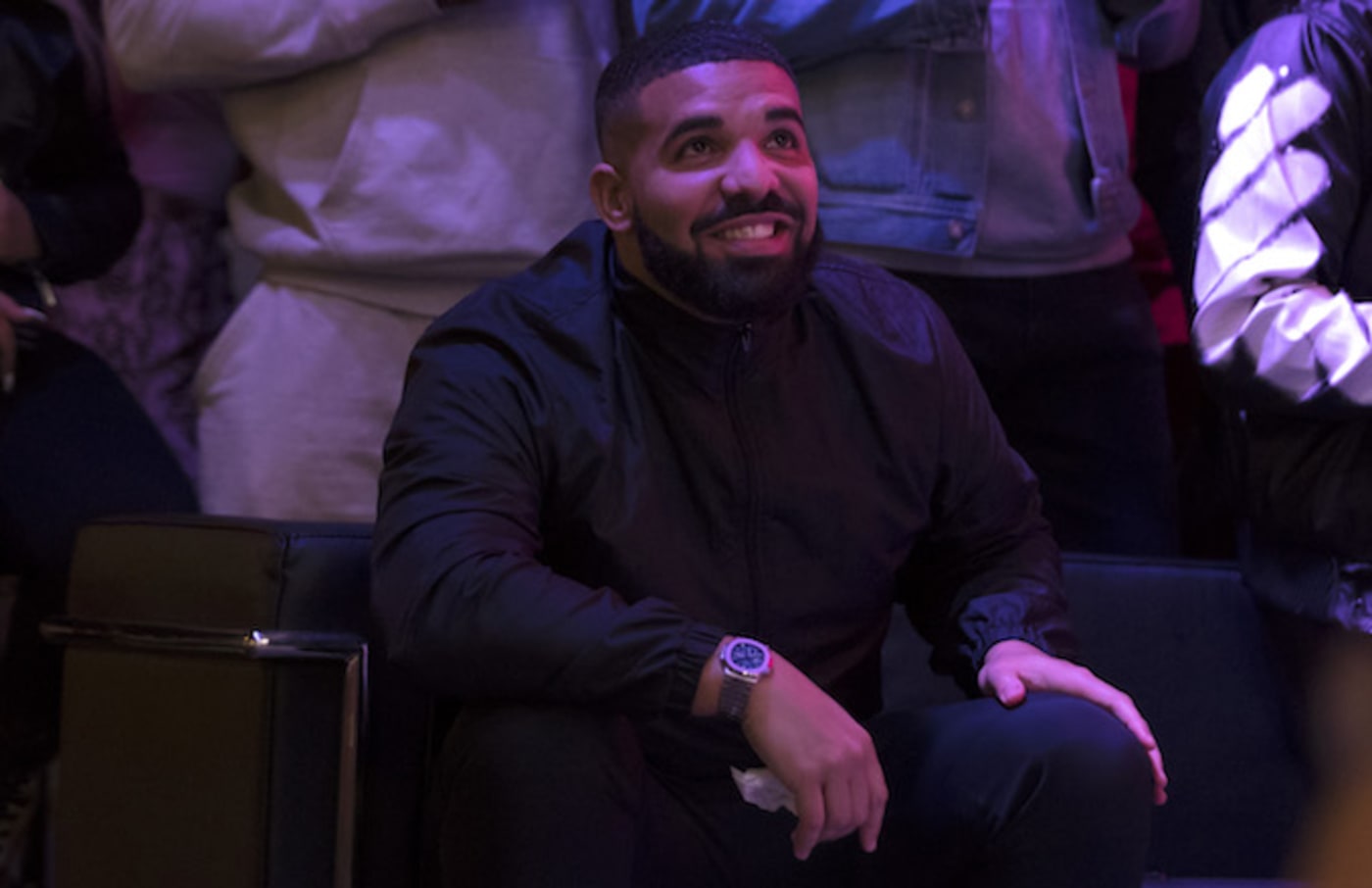 Drake watches a screen alongside other Toronto Raptors fans.