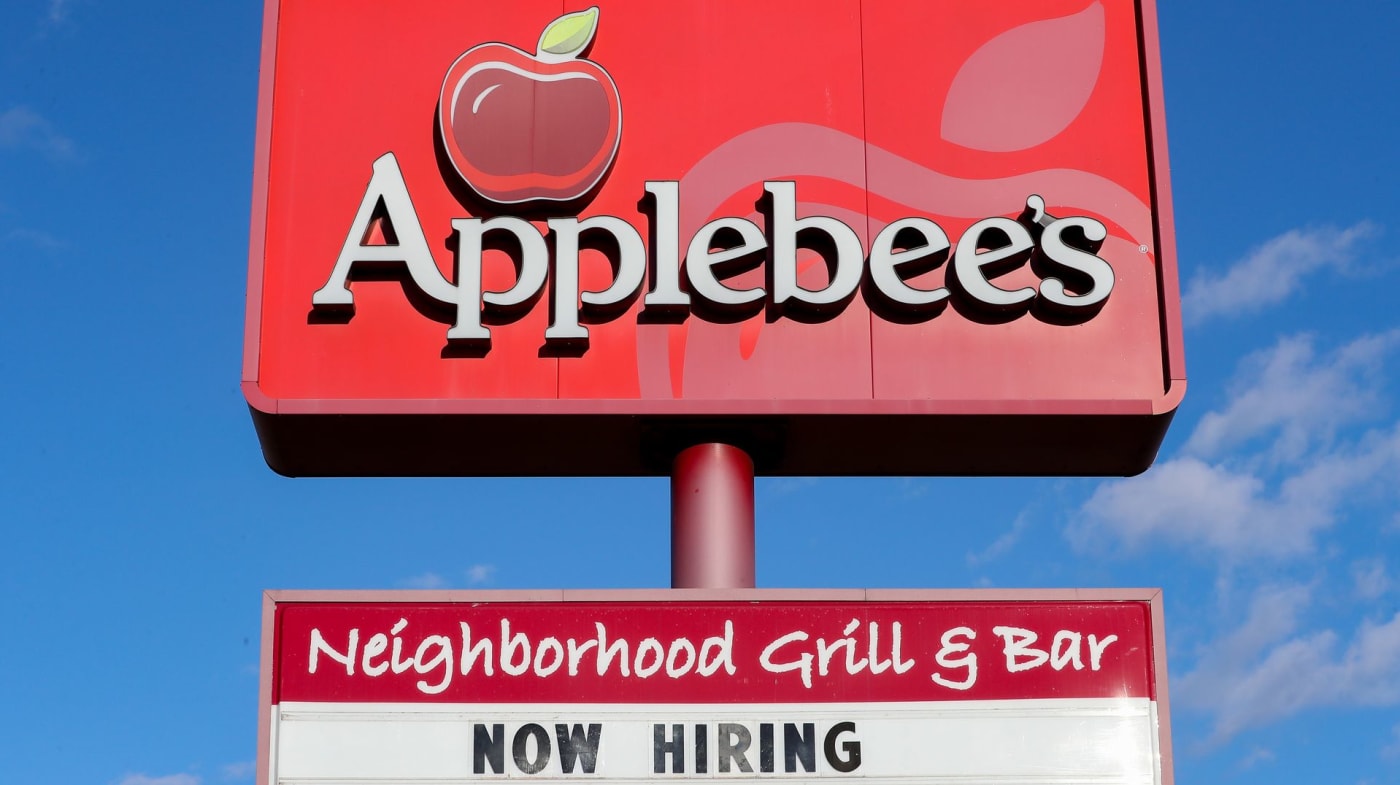 "Now Hiring" signs outside of an Applebee's