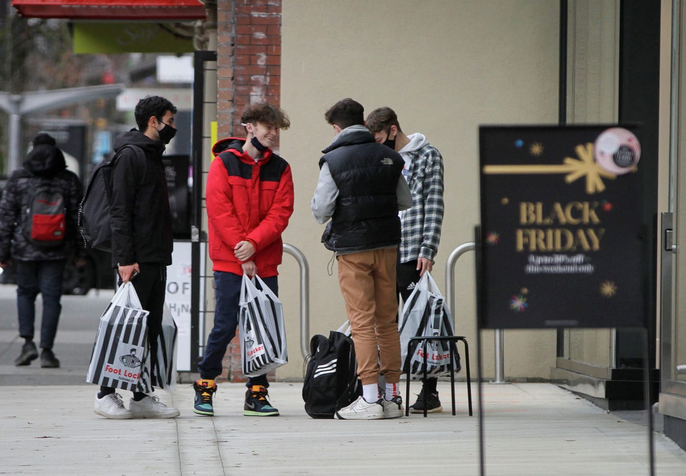 People carry their purchases during Black Friday shopping in downtown Vancouver, British Columbia
