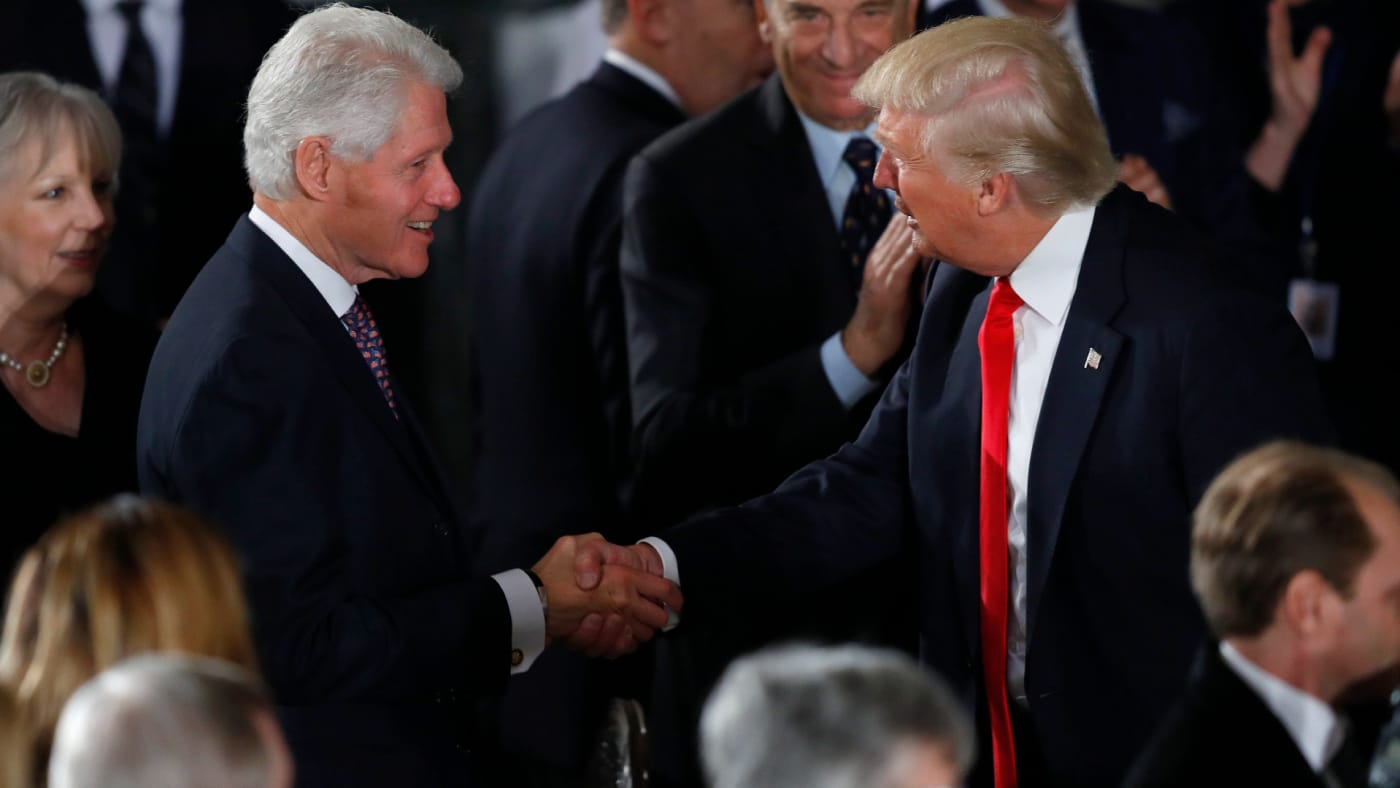 Bill Clinton and Donald Trump shake hands.