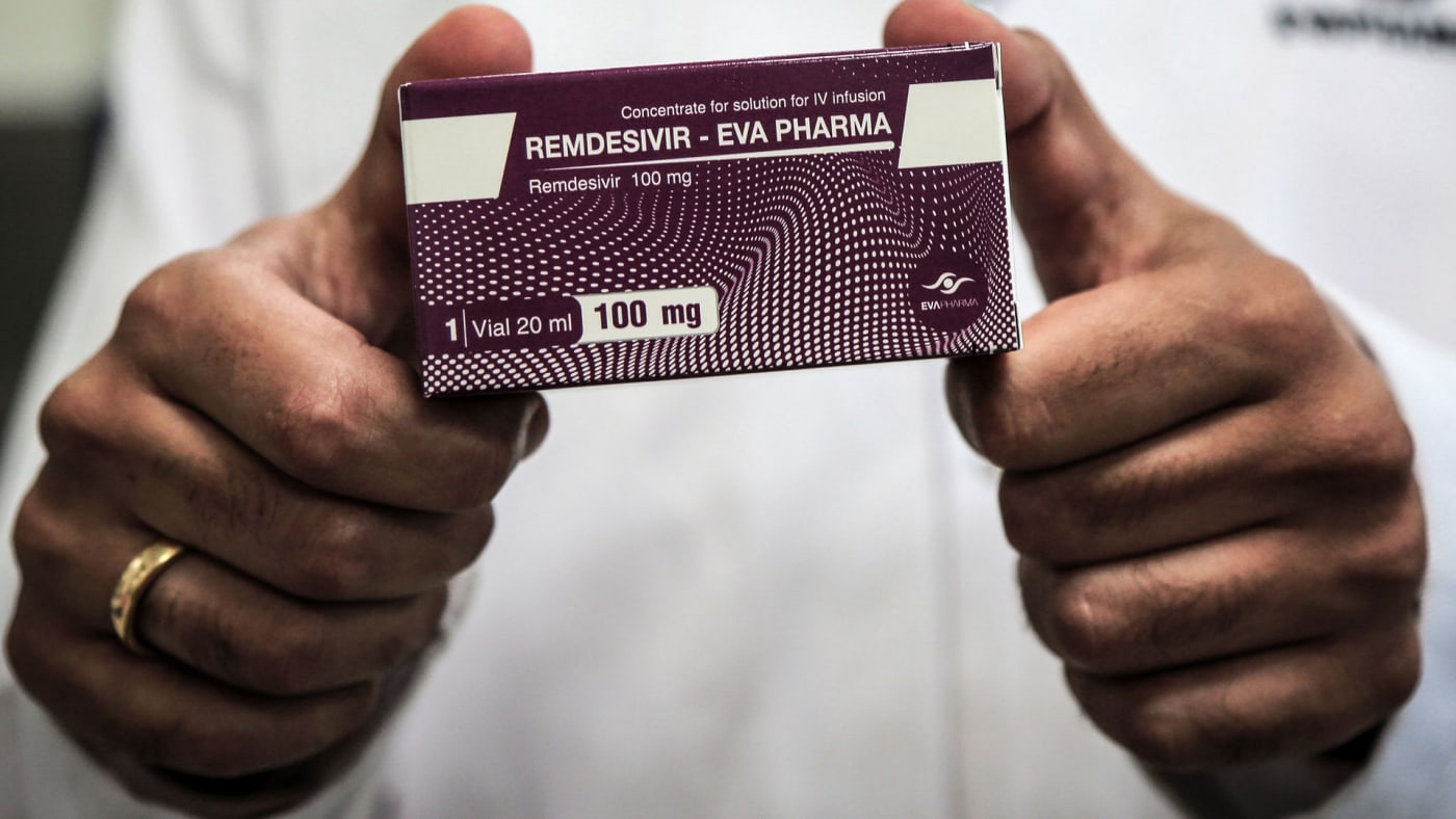 An Egyptian pharmaceutical company employee holds a pack containing vials of Remdesivir.