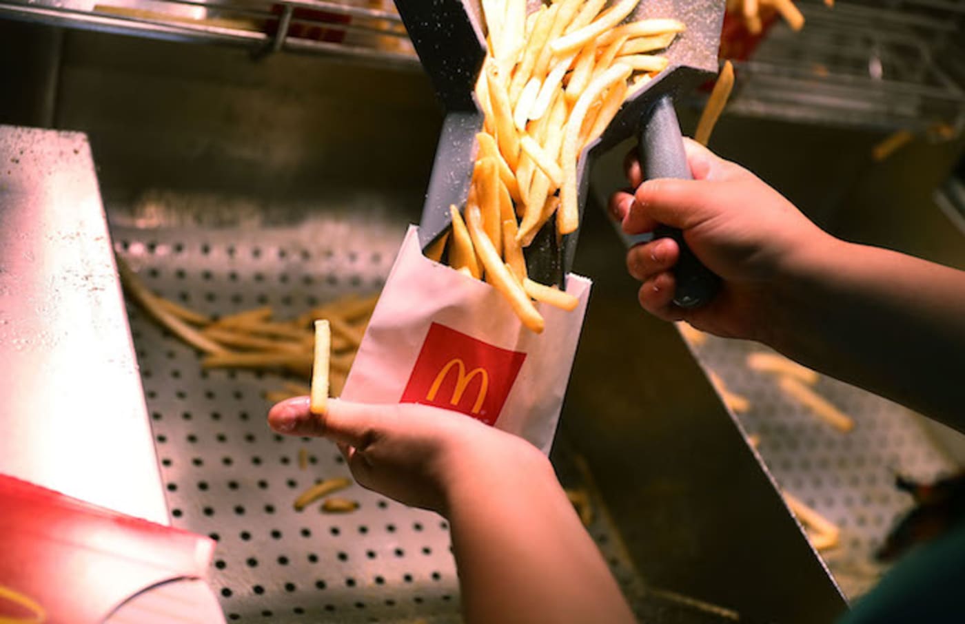 A  McDonald's crew member preparing fries.