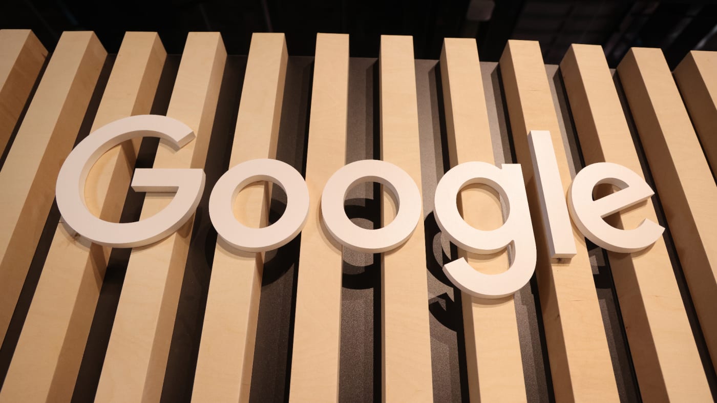 A wooden Google logo hangs at a stand.
