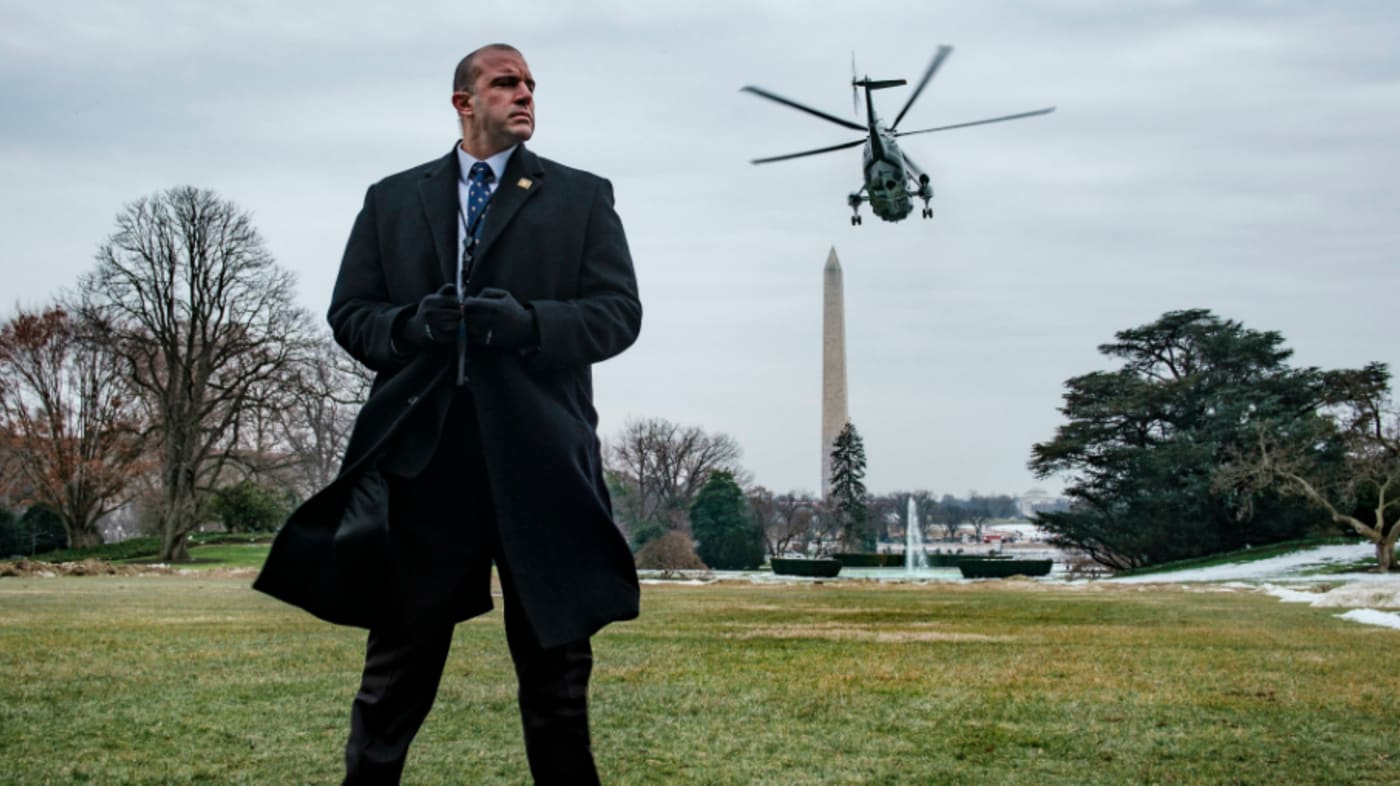 A Secret Service agent stands watch as President Trump departs on Marine One