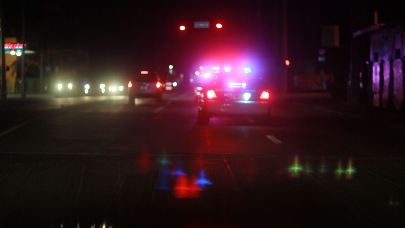 A City of Miami police car with lights ablaze responds to a call.
