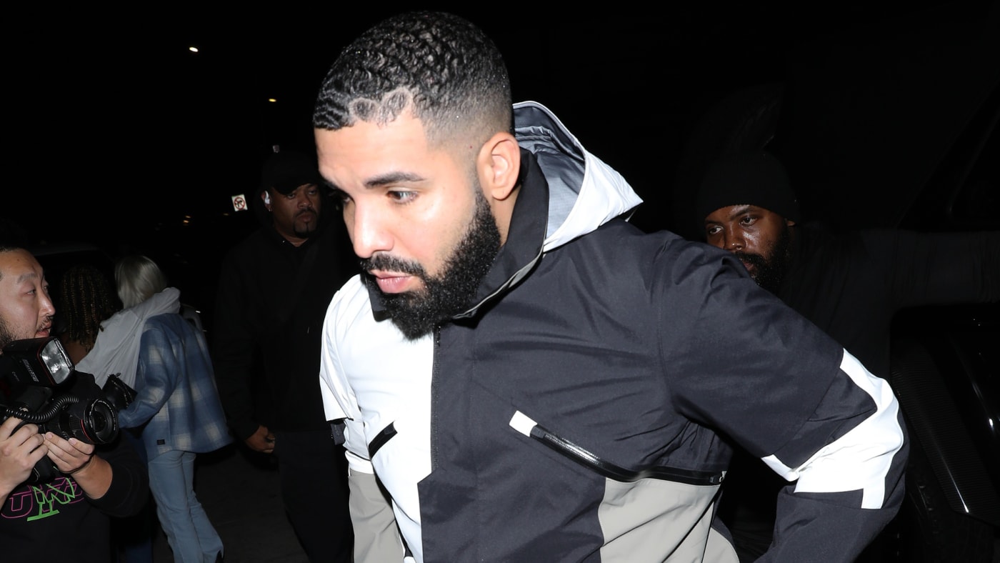 Drake is seen walking amid photographers.