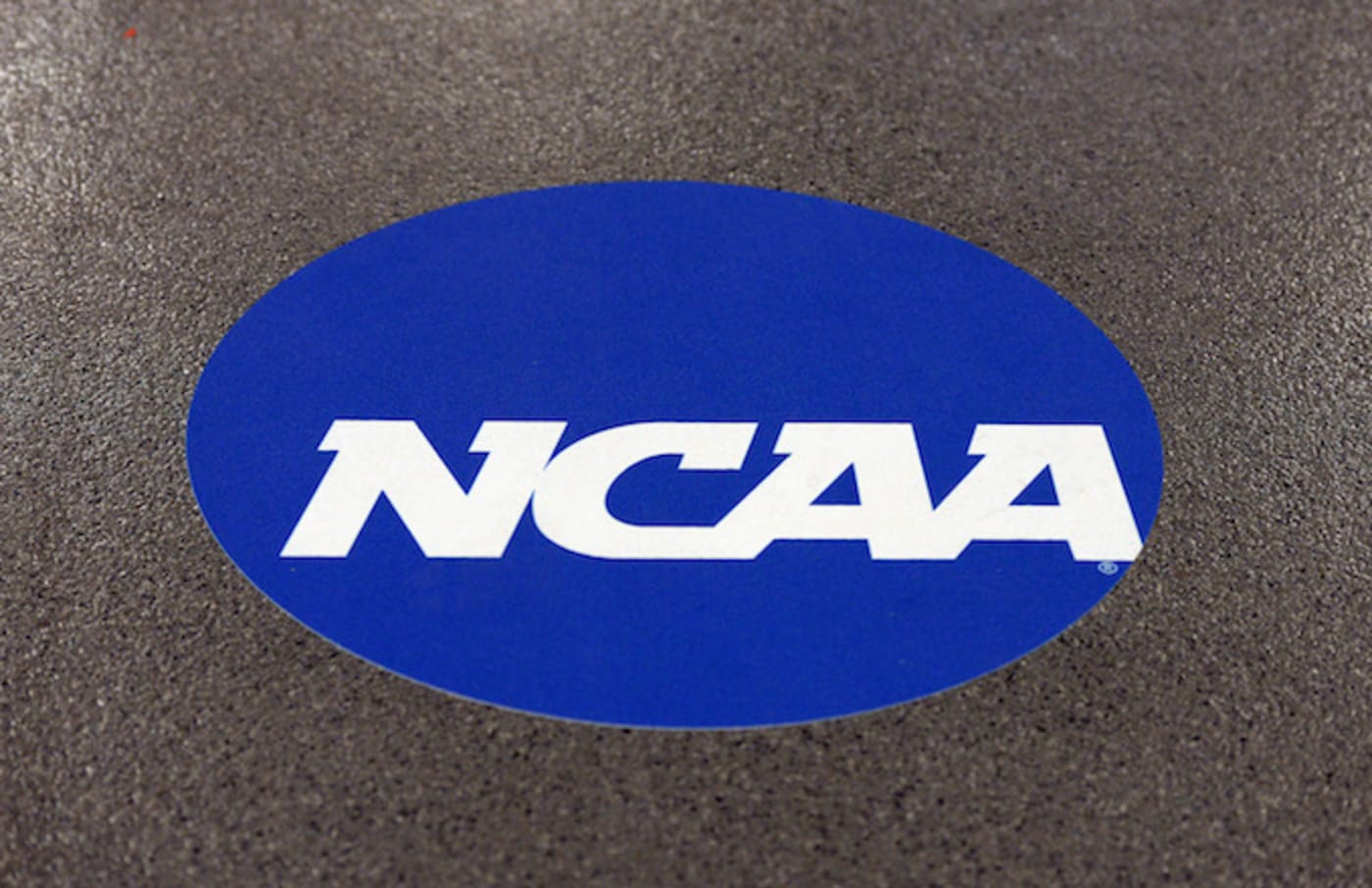 NCAA logo is displayed on the floor during the NCAA Men's Gymnastics Championship.