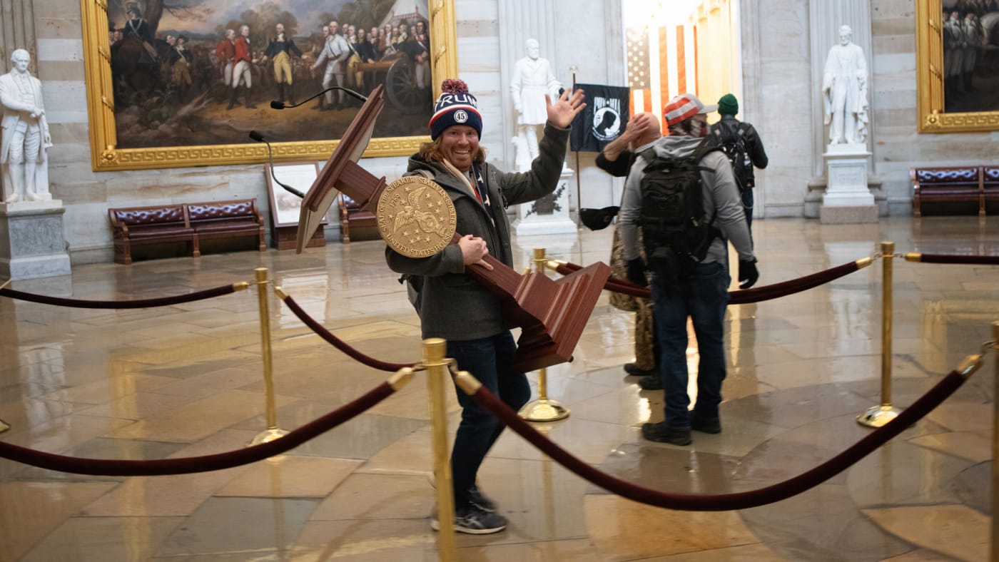 Man holding Nancy Pelosi’s lectern in Capitol riots