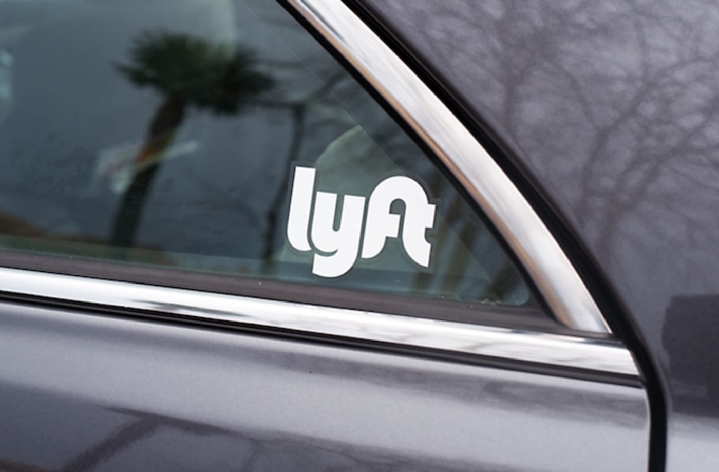 Close up of side window of a car used for the ridesharing service Lyft.