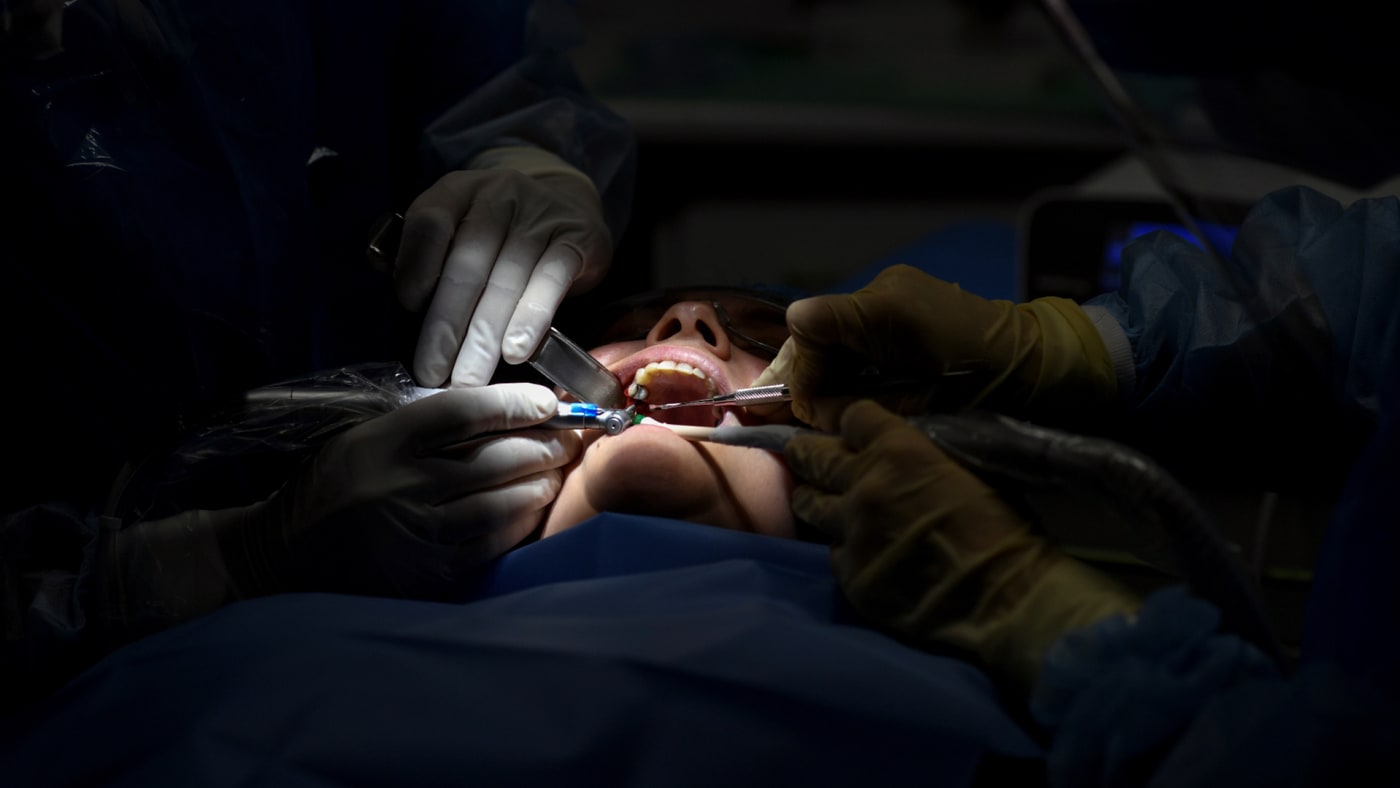 Dentists perform a dental procedure.