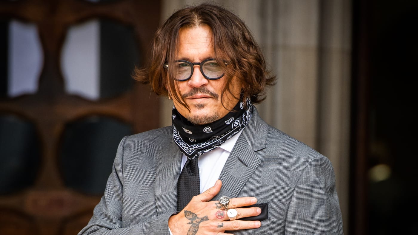 Johnny Depp acknowledges photographers outside Royal Courts of Justice.